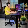 A man is playing a video game on a computer setup in a room. Produktbild-Vorschau