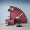 Two khaki bar stools are displayed in a studio setting with a red curved backdrop and a disco ball. Produktbild-Vorschau