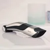 A Philips body groomer is placed on a reflective surface, likely a bathroom counter, with a blurred glass container in the background. Podgląd zdjęcia produktu
