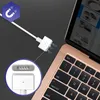 A white magnetic charger for a MacBook Air is shown connected to the laptop, with a close-up inset of the magnetic connector. Produktbild-Vorschau