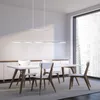 A modern dining room with a white table, chairs, and a long pendant light. Produktbild-Vorschau