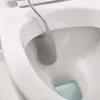 A close-up shot of a gray silicone toilet brush inside a white toilet bowl. Náhled obrázku produktu