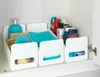 A set of three white storage bins filled with various bathroom items on a shelf inside a cabinet. Produktbild-Vorschau