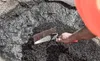 A close-up shot of asphalt being worked on with a trowel. Produktbild-Vorschau