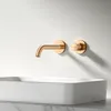 A rose gold faucet and control knob are mounted on a white wall above a white rectangular sink. Anteprima dell’immagine prodotto