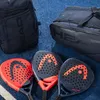 Three HEAD padel rackets and two HEAD bags are arranged on a blue surface. Podgląd zdjęcia produktu
