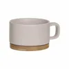 A light pink ceramic mug with a wooden base, shown against a white background. Podgląd zdjęcia produktu