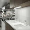 A professional kitchen scene with chefs working in the background and a sink area in the foreground. Produktbild-Vorschau