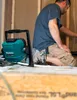 A person is working on a construction site with a work light nearby. Podgląd zdjęcia produktu
