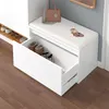 A white storage bench with an open drawer revealing shoes, placed on a wooden floor. Produktbild-Vorschau