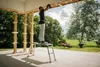 A man is standing on an adjustable work platform under a covered porch, working on the ceiling. Anteprima dell’immagine prodotto