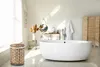 A bright, modern bathroom with a freestanding bathtub, sink, and a woven laundry basket. Náhled obrázku produktu
