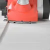 Close-up view of an electric planer working on a white surface. Produktbild-Vorschau