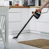 A person is using a steam mop in a kitchen. Podgląd zdjęcia produktu