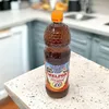 A bottle of Melfor Original vinegar condiment with honey and herbs sits on a speckled countertop in a kitchen setting. Produktbild-Vorschau