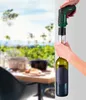 A person is using an electric corkscrew to open a bottle of wine outdoors, with a blurred background of a table setting and greenery. Produktbild-Vorschau