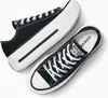 A pair of black Converse platform sneakers with white laces and soles, shown from a top-down diagonal angle on a white background. Voir les images du produit