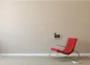 A red rocking chair is placed next to a wall-mounted tablet in a room. Podgląd zdjęcia produktu