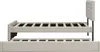 A side view of a beige upholstered bed frame with a pull-out trundle bed underneath, shown against a white background. Náhled obrázku produktu