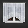 A white lace curtain with a decorative scalloped bottom edge is shown hanging in front of a window at night. Produktbild-Vorschau