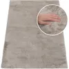 A hand is shown pressing into a soft, beige rug. Produktbild-Vorschau