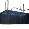 A modern, ceiling-mounted LED showerhead with water flowing and blue lights illuminated. Produktbild-Vorschau