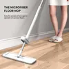 A person is using a microfiber floor mop on a wooden floor next to a wall. Podgląd zdjęcia produktu