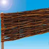 A close-up of a woven willow border for a garden bed against a bright blue sky. Produktbild-Vorschau