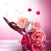 A pink star-shaped perfume bottle is surrounded by pink roses and raspberries, with water splashes in the background. Produktbild-Vorschau