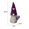 A decorative gnome figurine with a purple hat and a bouquet of purple flowers. Produktbild-Vorschau