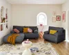 A living room scene with a sofa, armchair, and coffee table. Produktbild-Vorschau