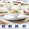 A table setting with porcelain dinnerware, including plates, bowls, and cutlery, set for a meal. Produktbild-Vorschau