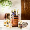 A collection of miniature whisky bottles arranged in and around a wooden barrel. Produktbild-Vorschau