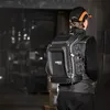 A person wearing a tool backpack in a warehouse-like setting. Náhľad obrázku produktu