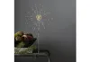 A decorative LED light shaped like a firework is displayed on a table next to a bowl of decorative items. Produktbild-Vorschau