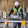 A construction worker is using a miter saw on a stand at a construction site. Produktbild-Vorschau