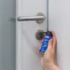 A hand is spraying lubricant into a door lock cylinder. Produktbild-Vorschau