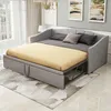 A gray sofa bed is shown in a room with a rug and artwork on the wall. Náhľad obrázku produktu