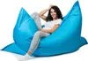 A woman is sitting on a large blue beanbag chair. Produktbild-Vorschau