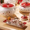 A collection of Christmas-themed ceramic serving dishes and bowls arranged on a wooden table. Anteprima dell’immagine prodotto