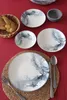 A table setting with plates, cutlery, bread, and a mortar. Anteprima dell’immagine prodotto