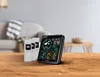 A weather station with three outdoor sensors is displayed on a wooden table in a living room setting. Náhled obrázku produktu