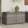 A grey poly rattan garden cabinet with two doors and white handles, placed on a patio with plants and a white wall in the background. Náhled obrázku produktu