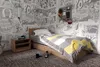 A bedroom with a comic book themed wallpaper, a bed, and a nightstand. Náhľad obrázku produktu