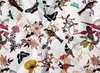 A flat lay of a white fabric with a repeating pattern of colorful birds and flowers. Produktbild-Vorschau