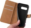 A hand holding a black phone case in front of a brown wallet-style phone case. Produktbild-Vorschau