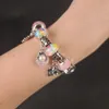 A close-up shot of a bracelet with charms on a person's arm. Náhled obrázku produktu