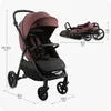 A burgundy and black stroller is shown in two views: one fully assembled and upright, and another folded for storage. Dimensions are indicated with measurement lines and text. Náhľad obrázku produktu
