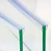 Close-up view of two transparent shower door seals attached to green glass panels. Anteprima dell’immagine prodotto