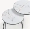 Two round nesting coffee tables with marble-like tops and dark metal frames. Voir les images du produit